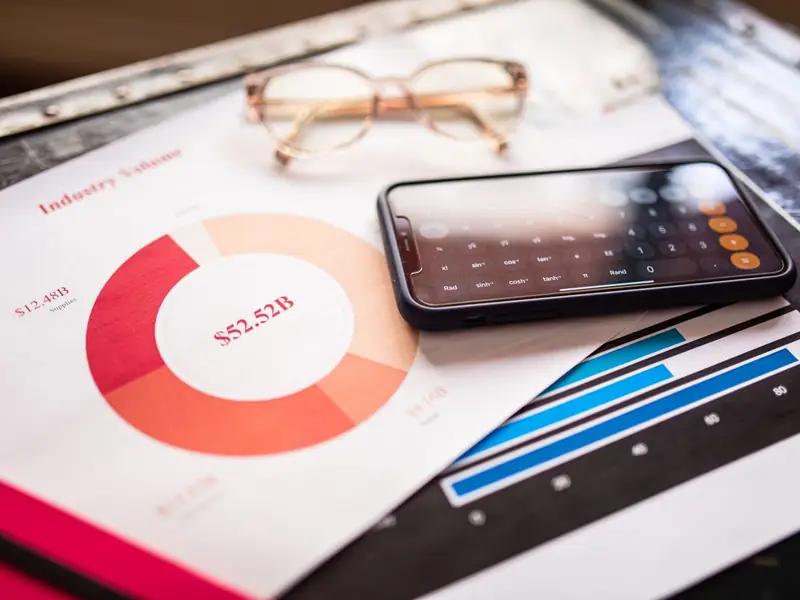 Printed charts with a phone calculator and a pair of glasses on top